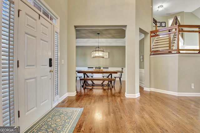 foyer entrance with wood-type flooring and an inviting chandelier