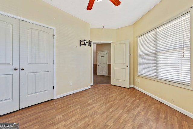 unfurnished bedroom with ceiling fan, light hardwood / wood-style floors, and a closet