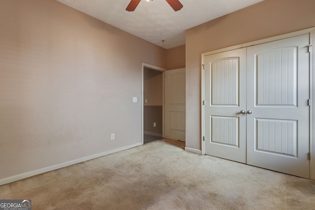 unfurnished bedroom with ceiling fan, a closet, and light carpet