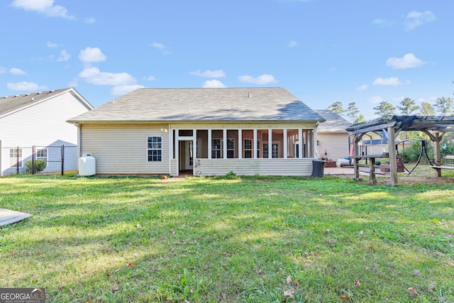 back of house with a lawn, a sunroom, and a pergola