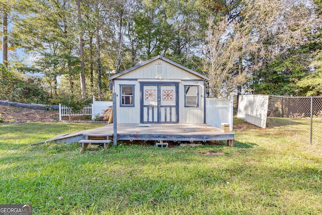 rear view of property with a storage unit and a lawn