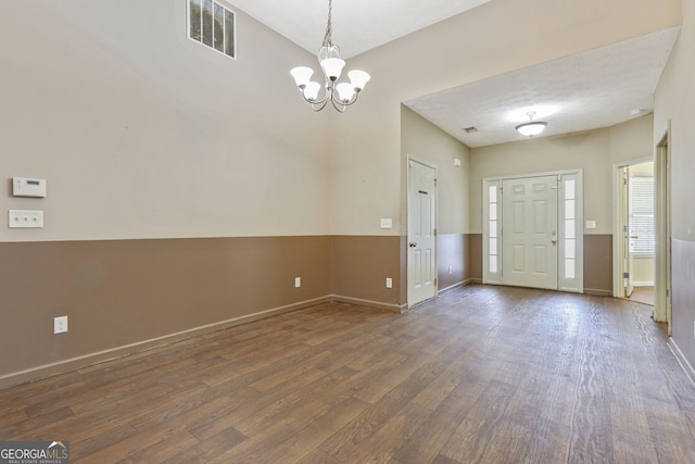 foyer with an inviting chandelier and dark hardwood / wood-style floors