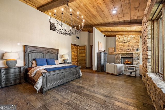 bedroom featuring dark wood-type flooring, wood ceiling, a stone fireplace, and beamed ceiling