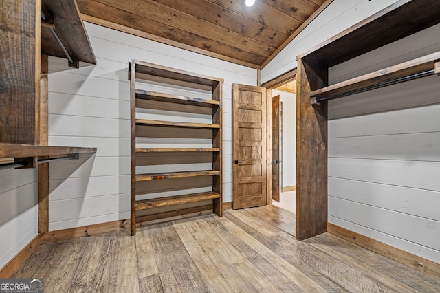 interior space with light hardwood / wood-style floors and vaulted ceiling