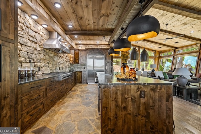 kitchen with wall chimney range hood, a kitchen island, appliances with stainless steel finishes, hardwood / wood-style flooring, and wooden ceiling