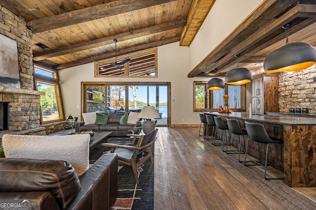 living room with wood ceiling, dark hardwood / wood-style floors, beam ceiling, a fireplace, and high vaulted ceiling