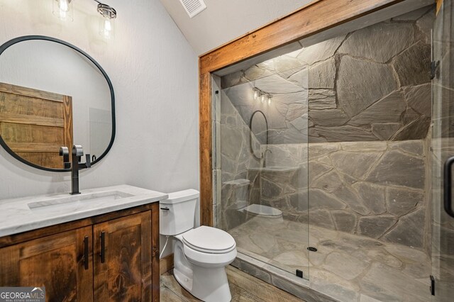 bathroom with vanity, toilet, lofted ceiling, and an enclosed shower