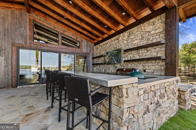 exterior space featuring a jacuzzi, beam ceiling, high vaulted ceiling, and wooden ceiling