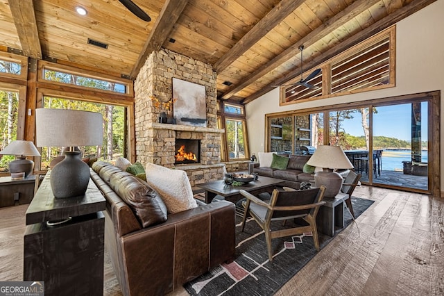 living room featuring a healthy amount of sunlight, hardwood / wood-style floors, a water view, and high vaulted ceiling