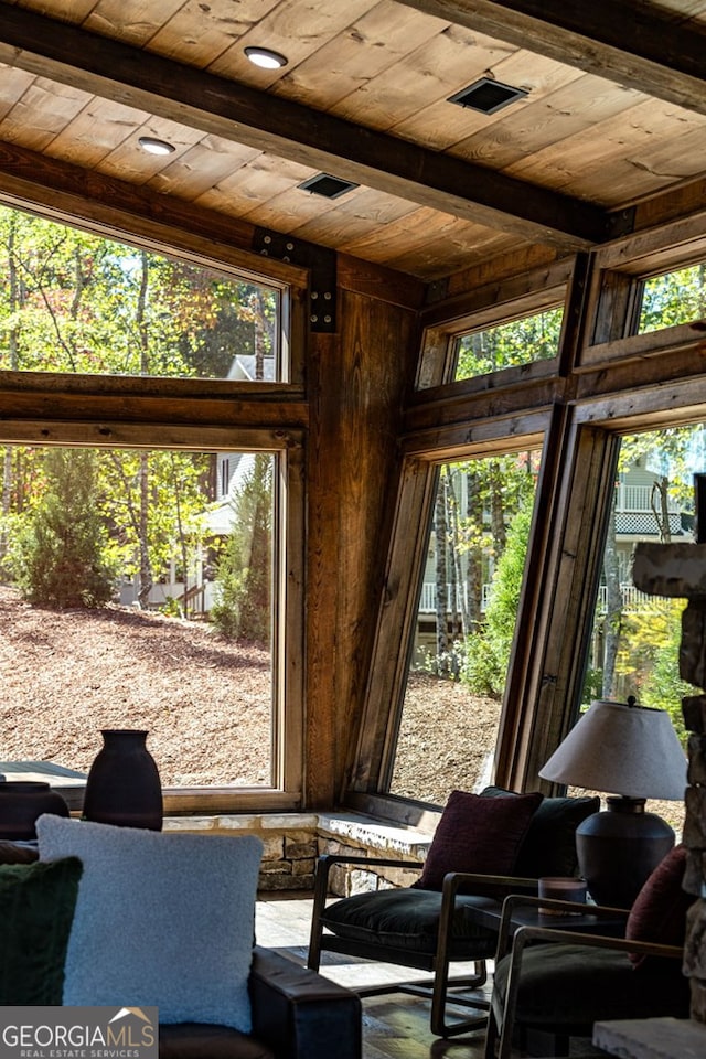 interior space with beamed ceiling, wooden ceiling, and plenty of natural light