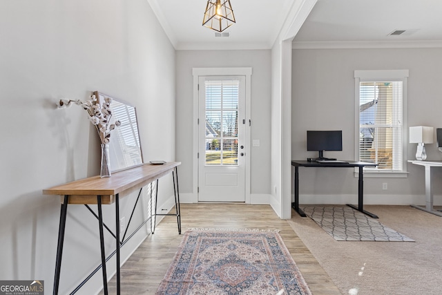 foyer featuring visible vents, crown molding, baseboards, and wood finished floors