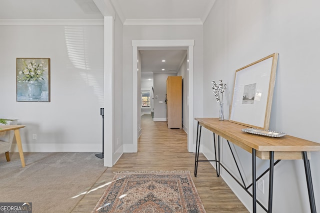 corridor with crown molding, baseboards, and wood finished floors