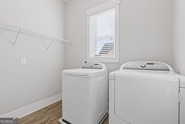 washroom with laundry area, independent washer and dryer, wood finished floors, and baseboards