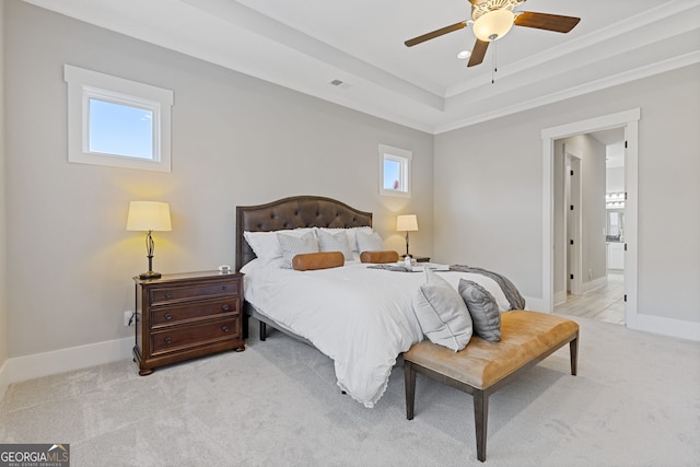 bedroom with light carpet, baseboards, and a raised ceiling