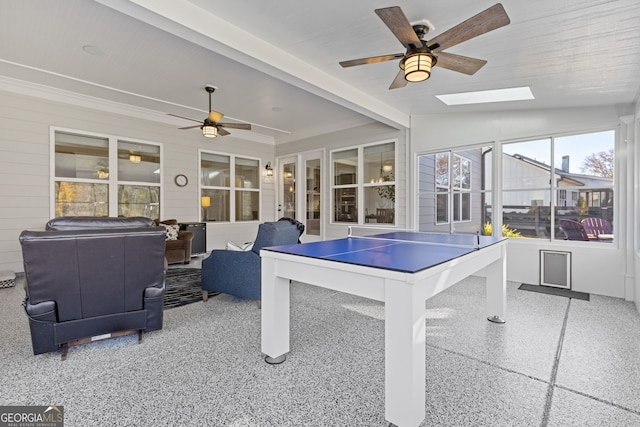 playroom with lofted ceiling with skylight and a ceiling fan