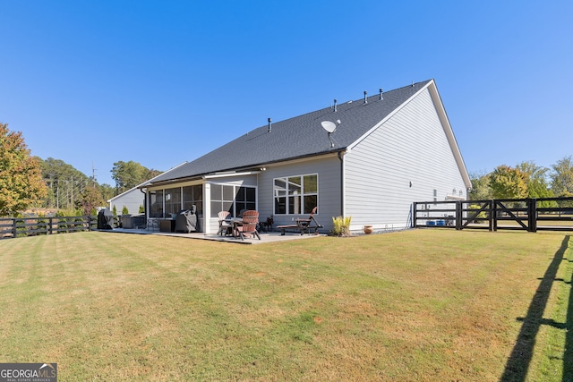 rear view of property with a lawn, a patio area, a fenced backyard, and a sunroom