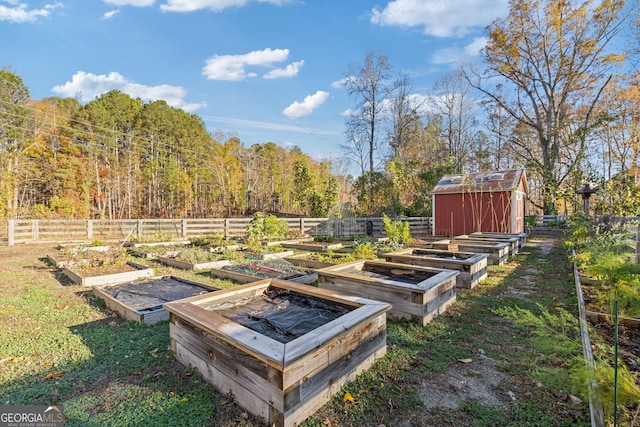 view of yard with a vegetable garden, a storage unit, an outdoor structure, and fence