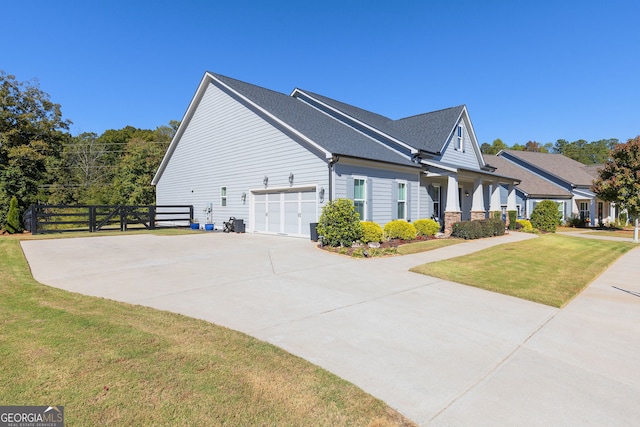 view of home's exterior featuring driveway, a garage, fence, and a lawn