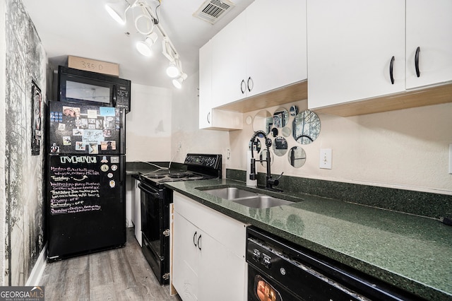 kitchen with sink, black appliances, white cabinets, and wood-type flooring