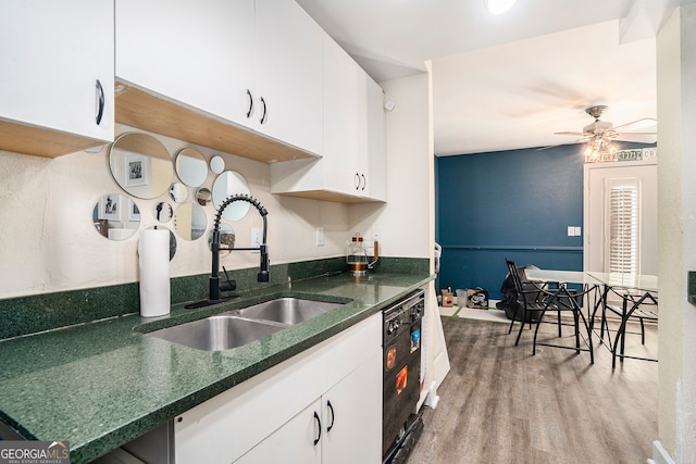 kitchen with white cabinets, black dishwasher, ceiling fan, wood-type flooring, and sink