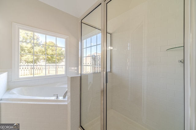 bathroom featuring shower with separate bathtub