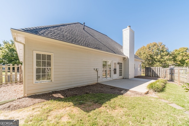 back of property featuring a patio and a yard