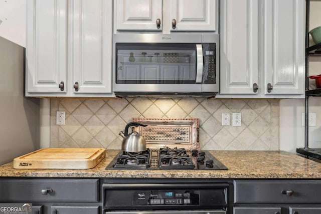 kitchen featuring light stone countertops, white cabinetry, appliances with stainless steel finishes, and tasteful backsplash