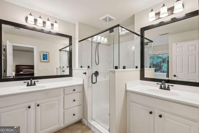 bathroom with walk in shower, vanity, and tile patterned floors