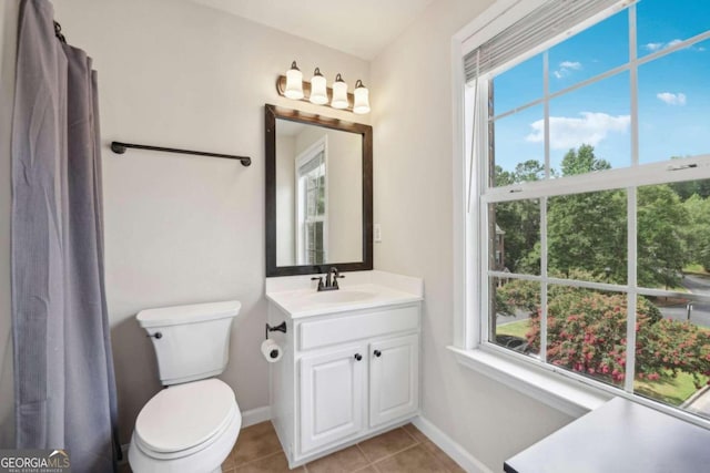 bathroom with vanity, a wealth of natural light, tile patterned flooring, and toilet