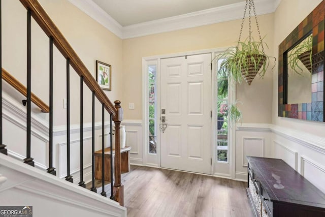 foyer with hardwood / wood-style floors and crown molding