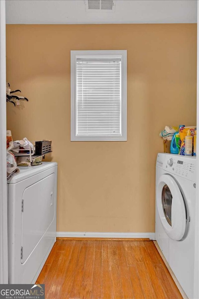 laundry area featuring separate washer and dryer and light wood-type flooring