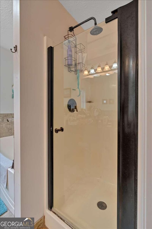 bathroom featuring walk in shower and a textured ceiling