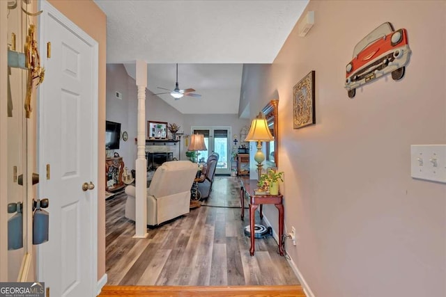 hall with vaulted ceiling and hardwood / wood-style floors