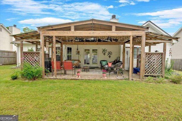 rear view of property with french doors, a patio area, a lawn, and a pergola