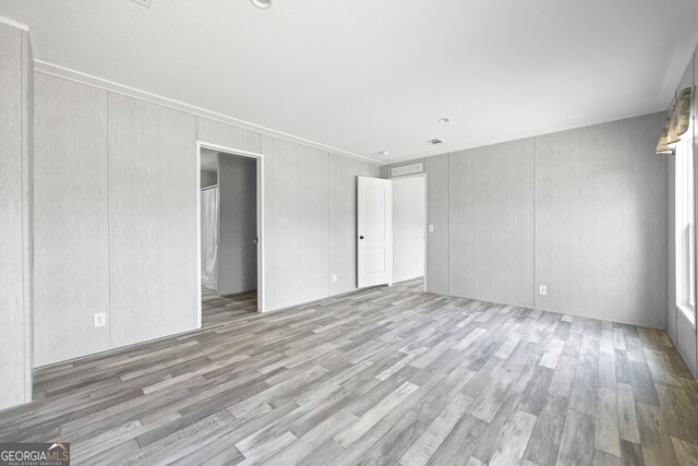 unfurnished room featuring dark wood-type flooring and crown molding