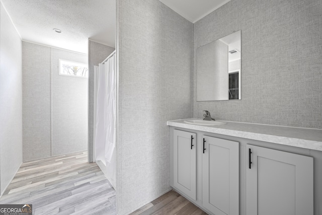 bathroom featuring vanity, hardwood / wood-style flooring, a textured ceiling, and a shower with shower curtain