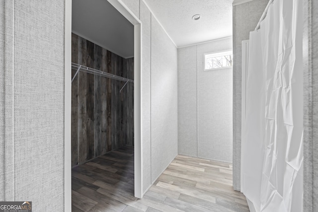 bathroom featuring wood-type flooring and a textured ceiling