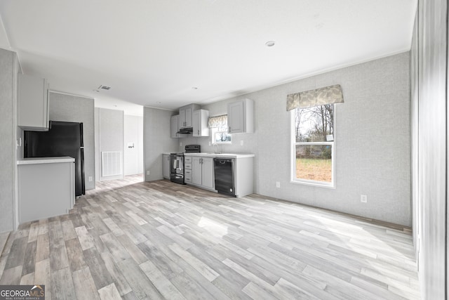 unfurnished living room featuring sink and light hardwood / wood-style flooring