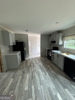 kitchen with gray cabinetry, light hardwood / wood-style floors, black appliances, and sink