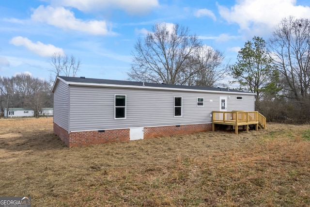 back of property featuring a yard and a deck