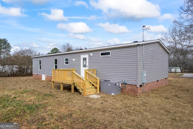 back of property featuring a yard and a deck