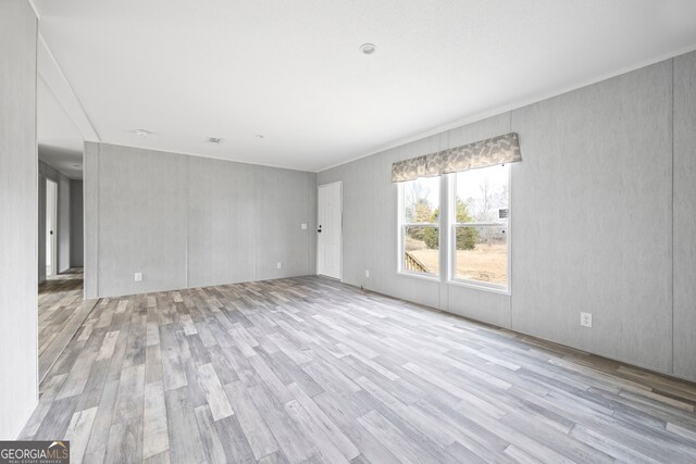 empty room with ornamental molding and hardwood / wood-style floors