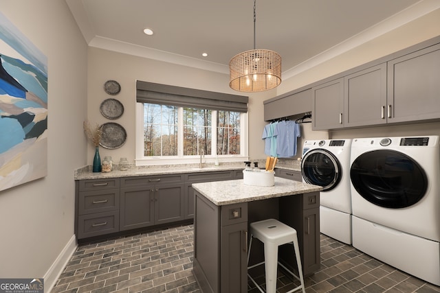 washroom featuring sink, crown molding, cabinets, and washing machine and clothes dryer