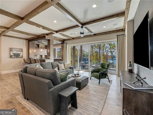 living room with beamed ceiling, light hardwood / wood-style floors, and a healthy amount of sunlight