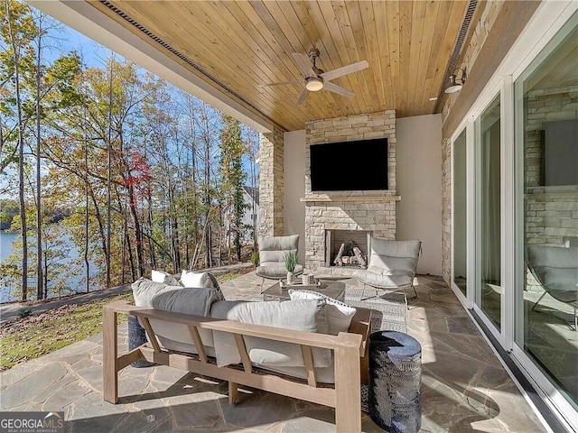 view of patio with an outdoor living space with a fireplace and ceiling fan