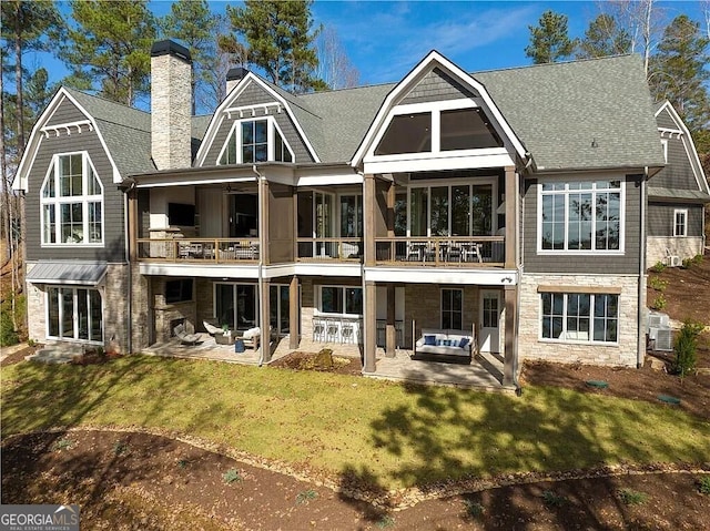 back of house with a patio, a lawn, and a balcony