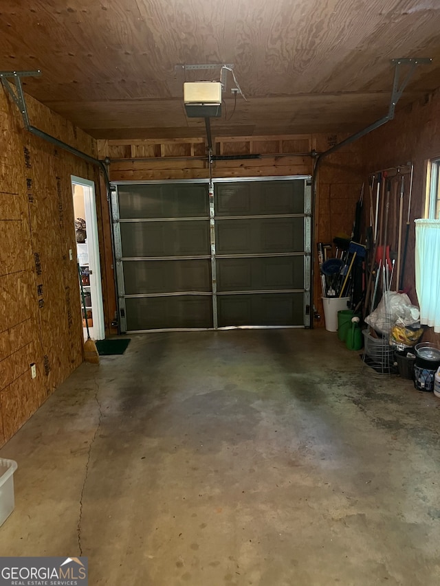 garage featuring a garage door opener and wooden ceiling