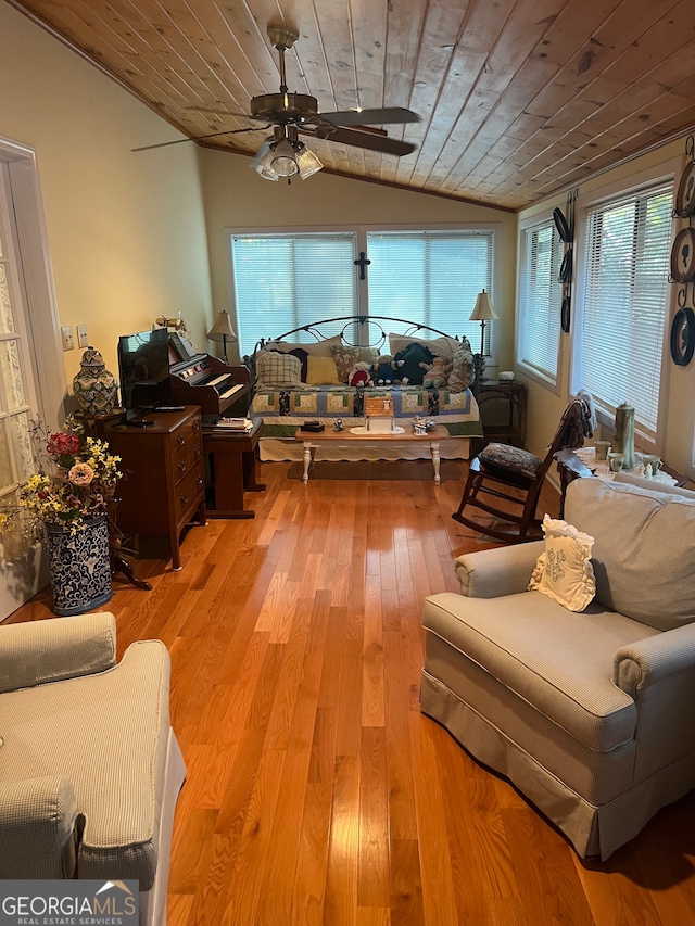 sunroom / solarium with lofted ceiling, wooden ceiling, and ceiling fan