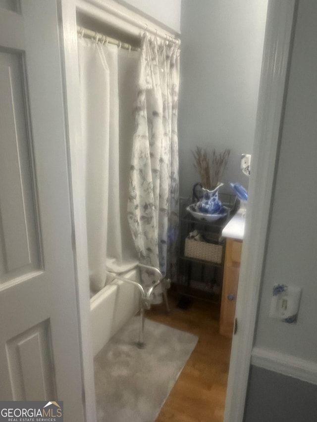 bathroom with shower / bath combination with curtain and wood finished floors