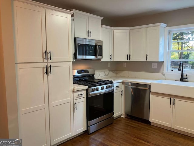 kitchen featuring dark wood-type flooring, stainless steel appliances, and white cabinets